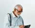 A man in a dress shirt and suspenders holding a tablet